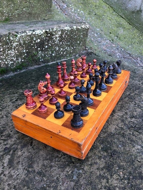 Vintage schackbräde med röda och svarta pjäser utomhus